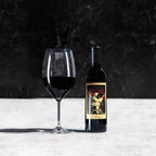 Wine bottle and glass on a textured surface with a dark background