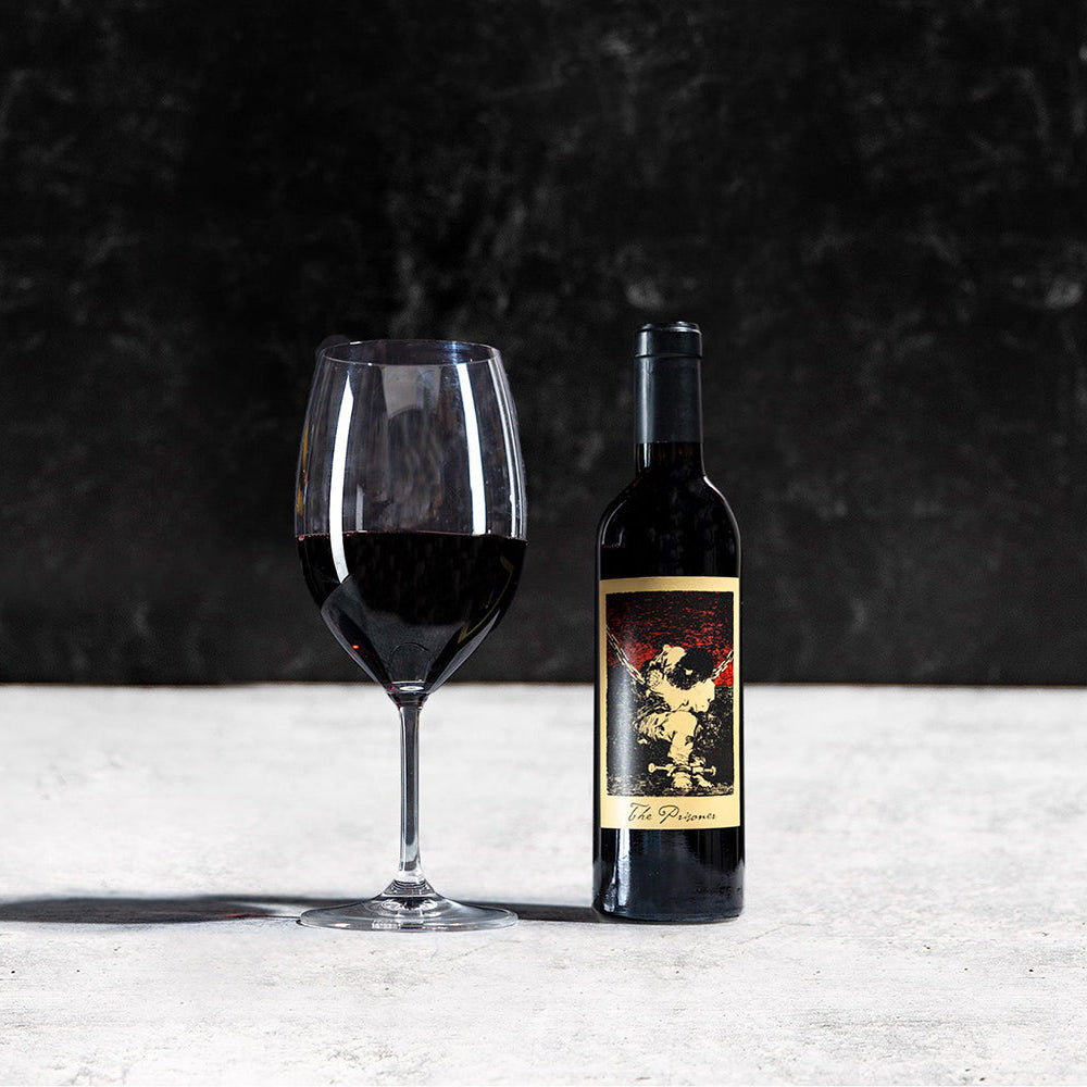 Wine bottle and glass on a textured surface with a dark background