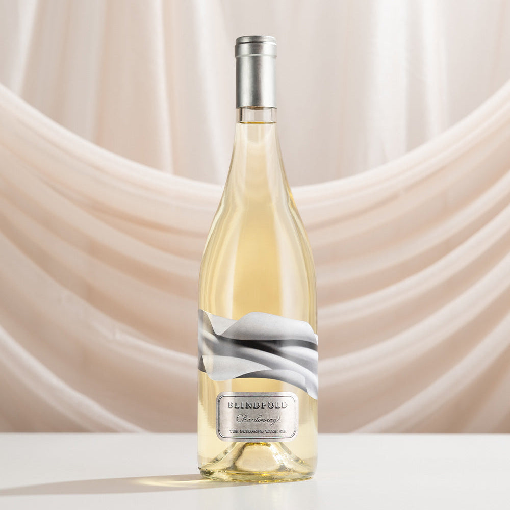 Bottle of Blindfold Chardonnay on a beige draped background