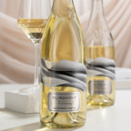 Two bottles of Blindfold Chardonnay with a glass of wine on a light background