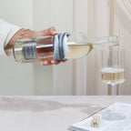 Person pouring wine into a glass on a table 
