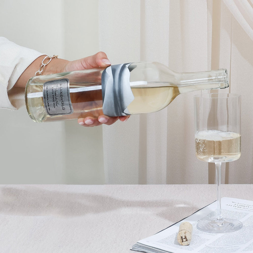 Person pouring wine into a glass on a table 