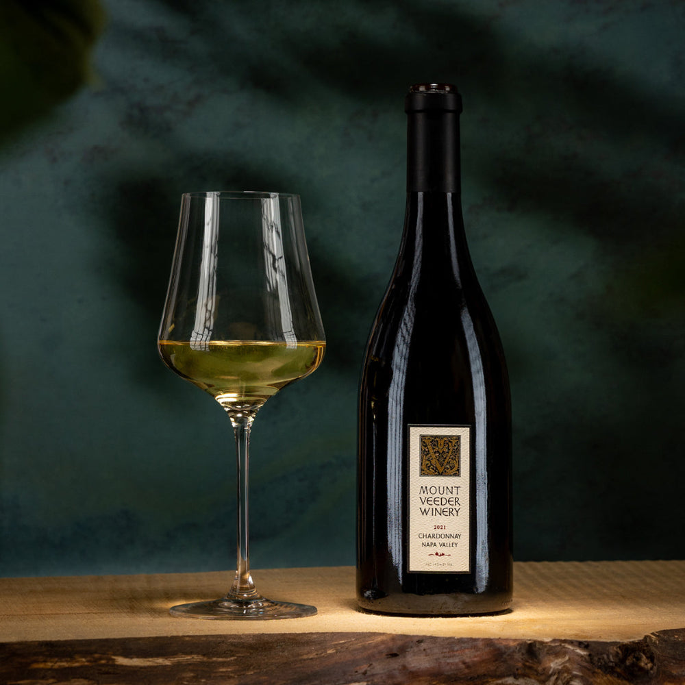 Bottle and glass of wine with Mount Veeder Winery label on a dark background