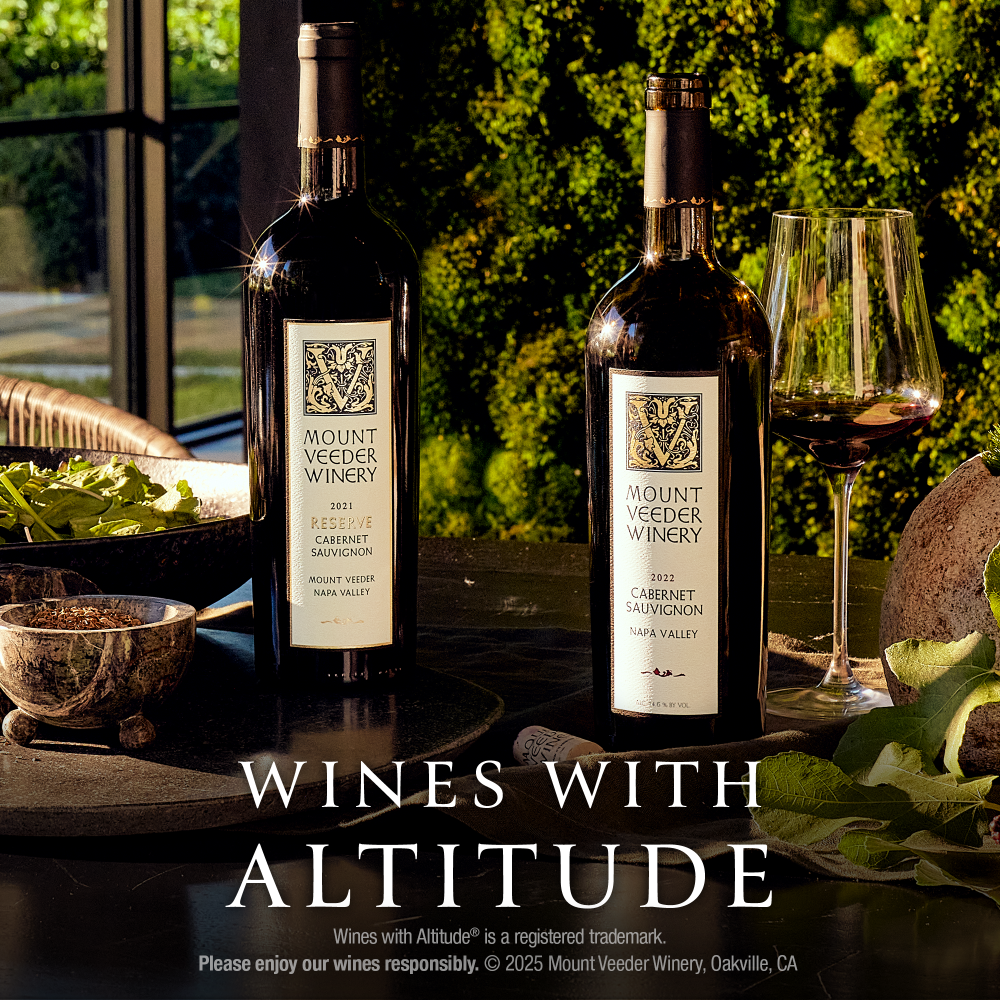 Two bottles of Mount Veeder Winery red wine, alongside a glass of red wine, set on a table with a green mossy background. WINES WITH ALTITUDE is printed at the bottom of the image