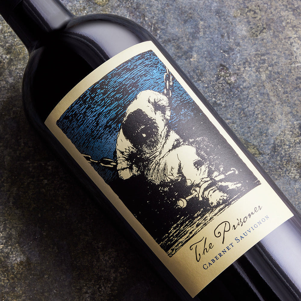 Wine bottle with 'The Prisoner' label featuring an illustration of a prisoner in chains.