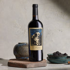 A bottle of The Prisoner Cabernet Sauvignon on a textured surface with decorative elements