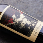Wine bottle label with artistic depiction of a person and text 'The Prisoner' on a dark surface.
