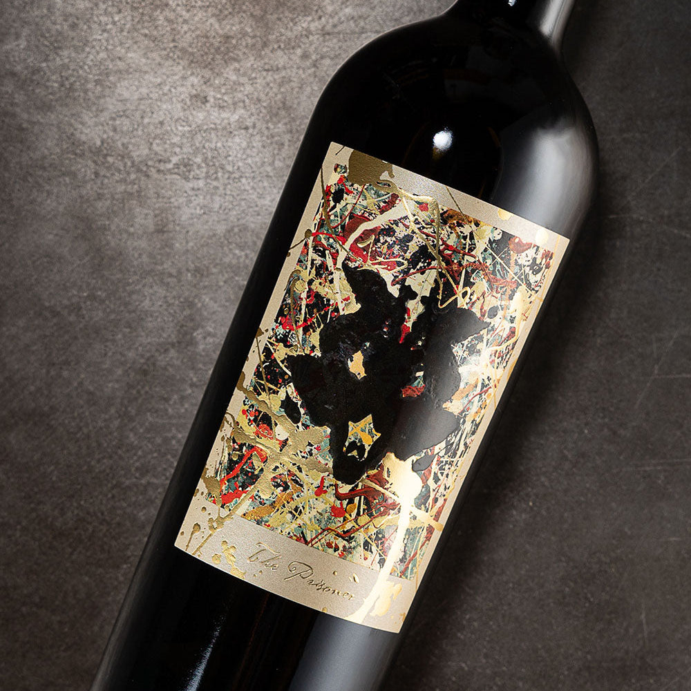 A bottle of The Prisoner Winemaker Series with a decorative label on a gray background