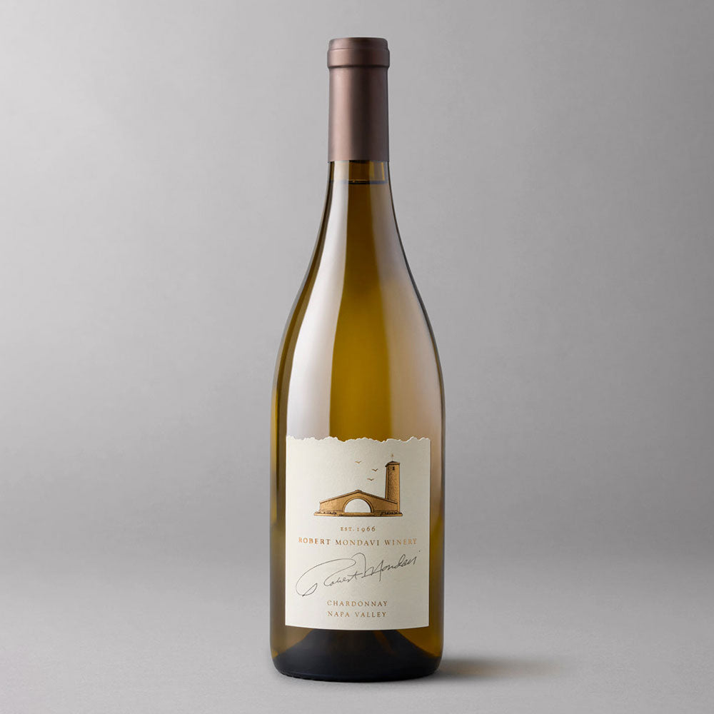 A bottle of Robert Mondavi Winery Chardonnay , featuring a cream-colored label with a brown illustration of an arch and a tower, set against a solid gray background.