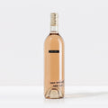 A bottle of 2023 SALDO White Zinfandel wine with a pink label and a clear bottle showing the light pink hue of the wine inside.