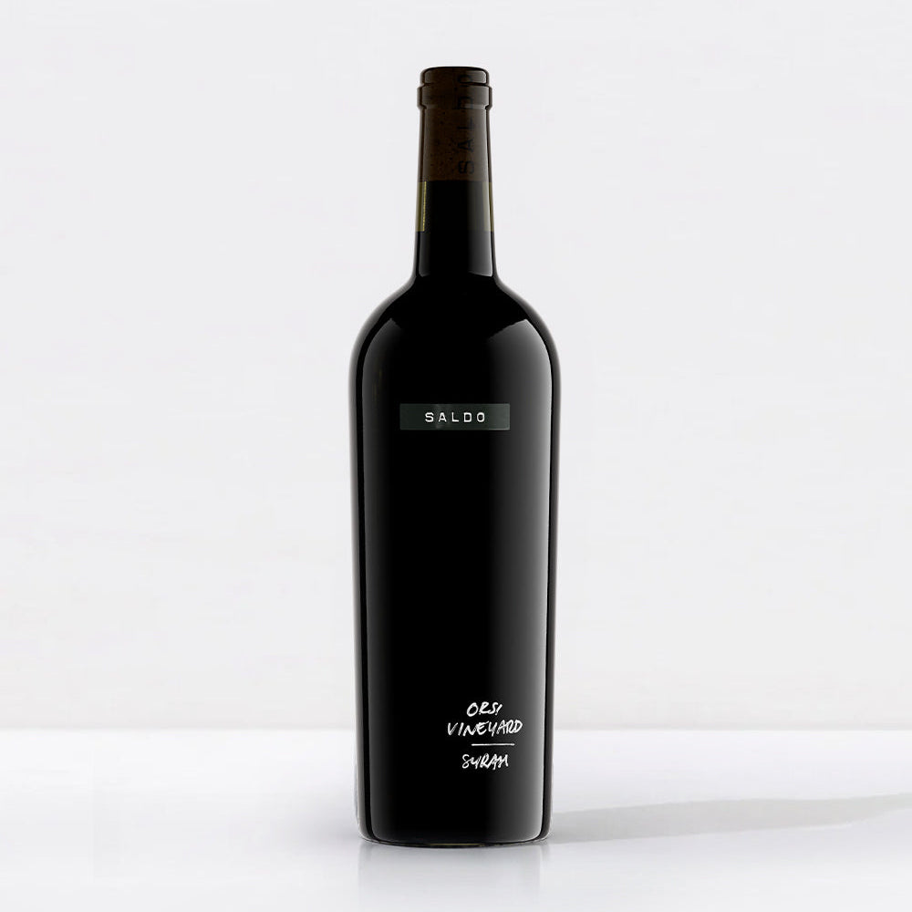 A dark glass wine bottle with a black label reading 'SALDO' and 'ORSI Vineyard Syrah' near the bottom, photographed against a clean white background.