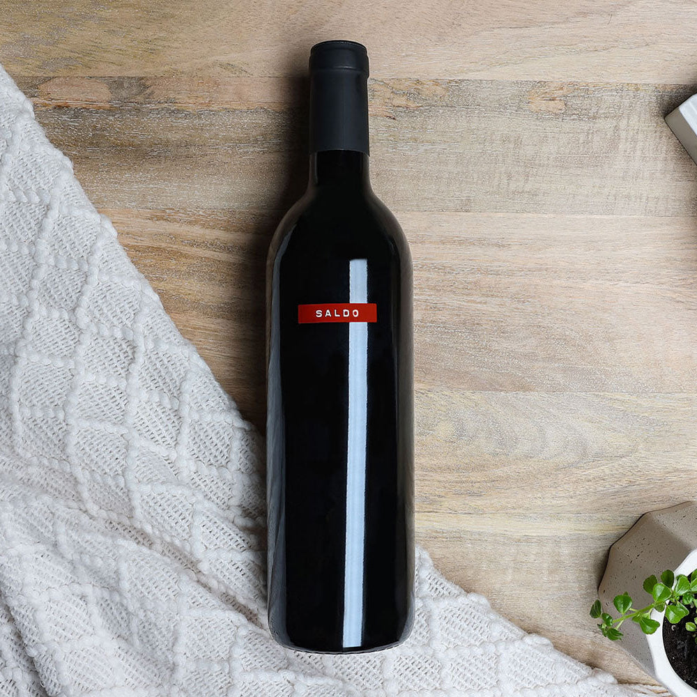 A bottle of SALDO Zinfandel on a wooden surface