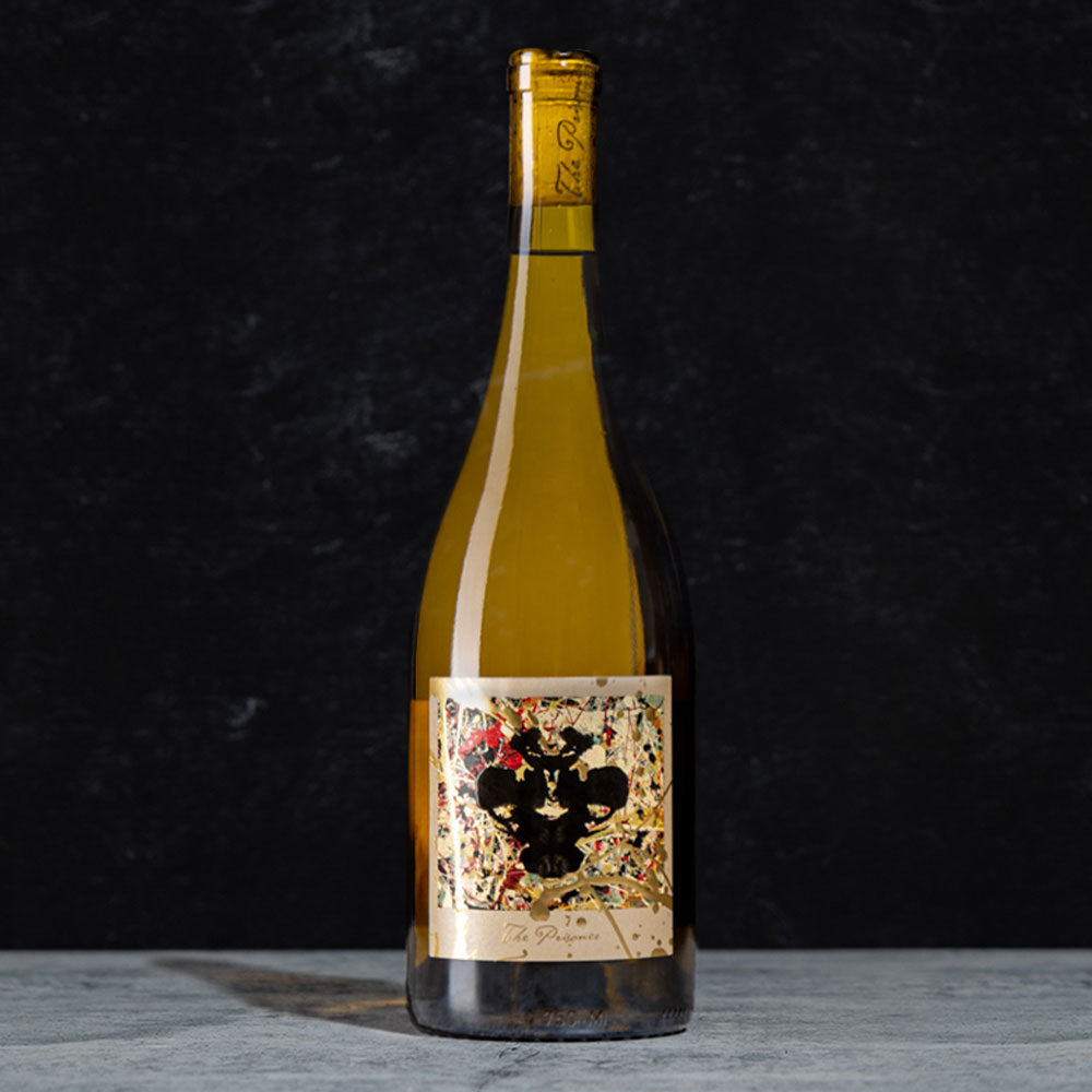 A bottle of the Winemaker Series Sweet White wine with a detailed black, red, and gold label, standing on a gray surface against a dark textured background.