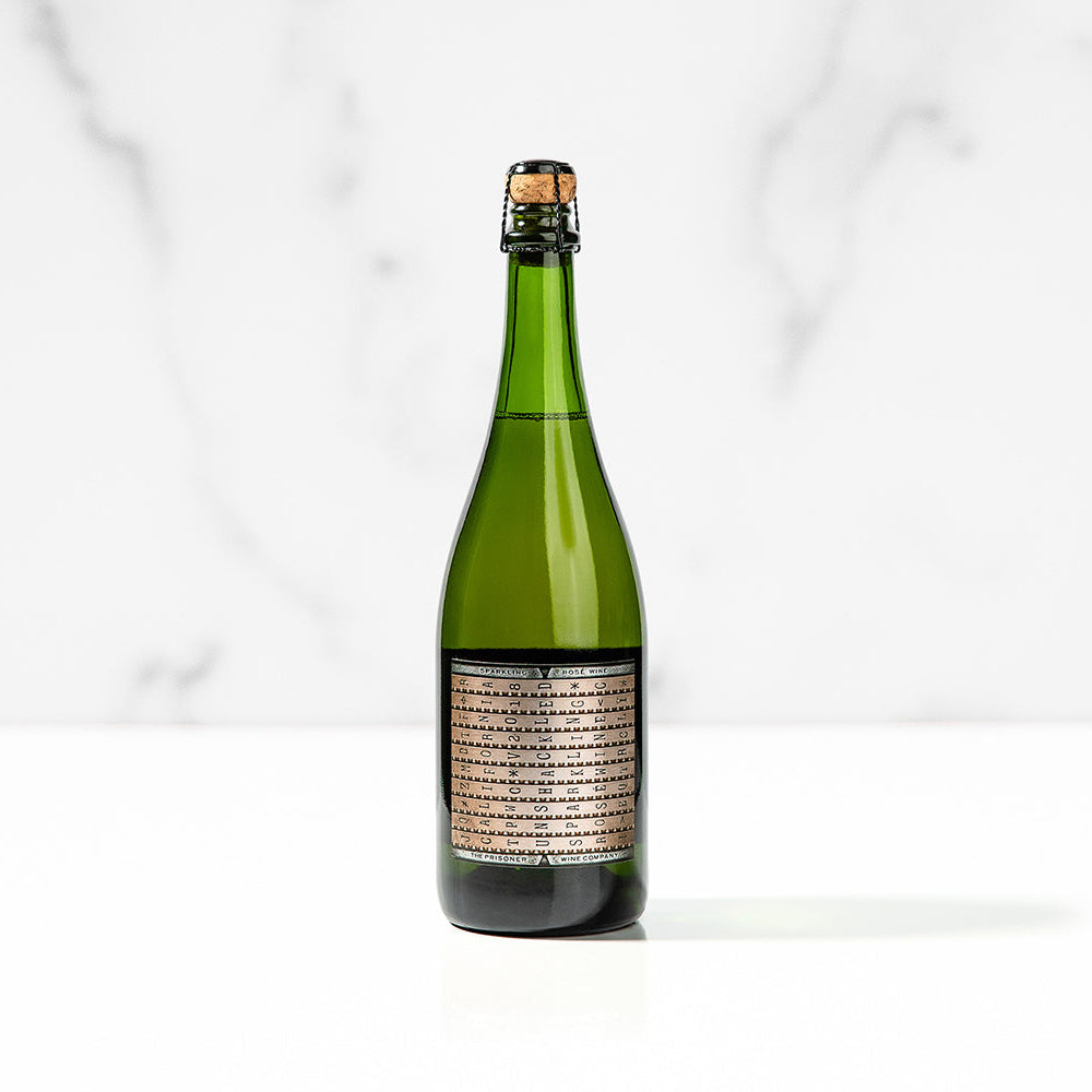 A bottle of Unshackled Sparkling Rose on a white marbled background