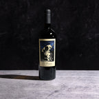 A bottle of The Prisoner Cabernet Sauvignon on a gray background with a sharp shadow