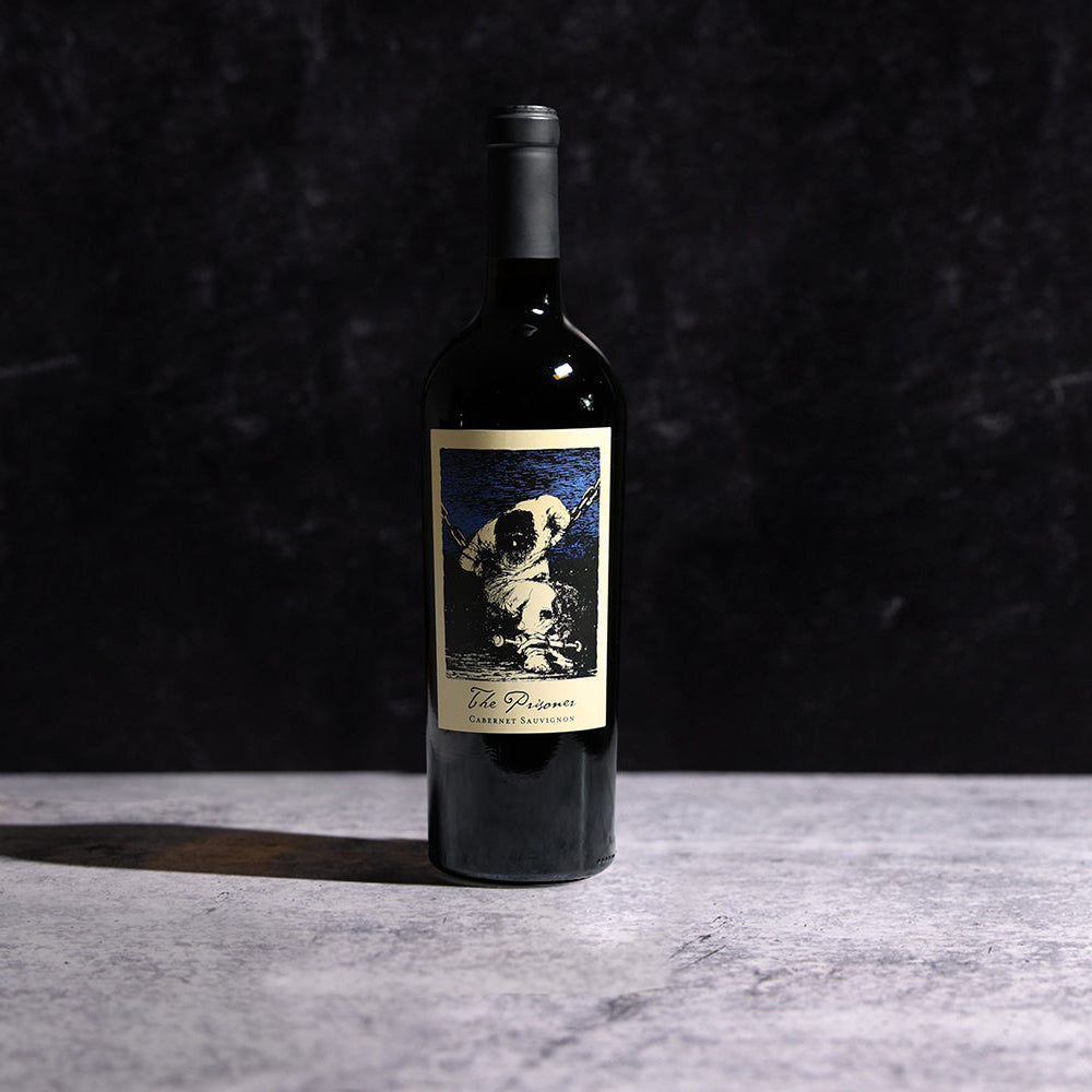 A bottle of The Prisoner Cabernet Sauvignon on a gray background with a sharp shadow