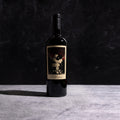 A bottle of The Prisoner Red Blend with a label on a dark background