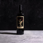 A bottle of The Prisoner Red Blend with a label on a dark background